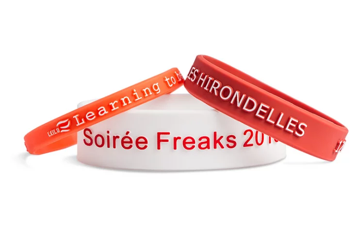Ce bracelet d'activité en silicone possède un texte en relief qui peut être recouvert parmi 2000 couleurs de caoutchouc au choix.
